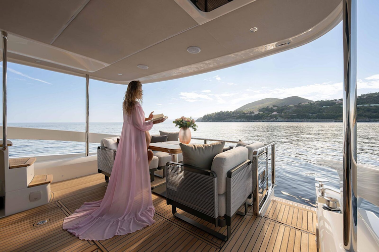woman in long pink dress standing on cockpit of navetta 50