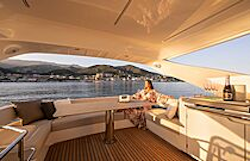 woman enjoying the view from the flybridge dining area - navetta 50