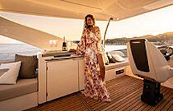 woman in dress pouring champagne on flybridge deck