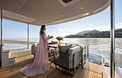 woman in long pink dress standing on cockpit of navetta 50