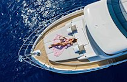 woman lying on the bow sunpads enjoying the warmth